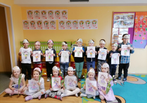 Grupowe zdjęcie dzieci z wykonanymi pracami z okazji Dnia Kobiet