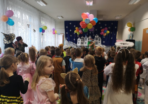 wodzirej pokazuje różne figury ,dzieci go naśladaują