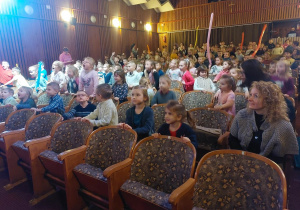 dzieci stoją przy swoich krzesłach