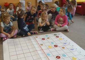 Dzieci siedzą na dywanie, wspólne zdjęcie
