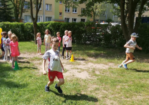 Wyścig rzędów - chłopiec biegnący z gazetą na klatce piersiowej.