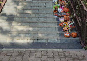 Wystawa dyniowych stworków na schodach do przedszkola.