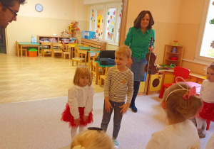 Dzieci stoją na środku i czekają na polecenia prowadzącego.