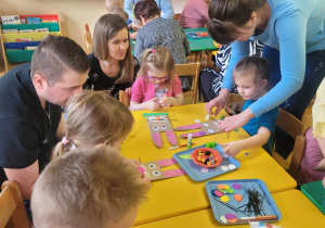 Dzieci wykonują pracę przy stolikach.