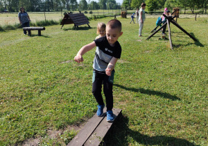 Chłopiec przechodzący po ruchomej kładce.