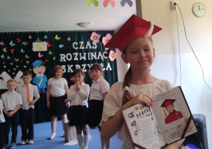 Zdjęcie dziewczynki z dyplomem ukończenia przedszkola