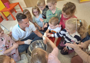 Doktor wśród dzieci prezentujący zakłądanie gipsu.