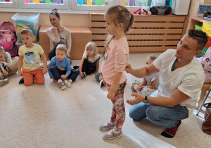 Dziewczynka i doktor prezentujący badanie pleców.