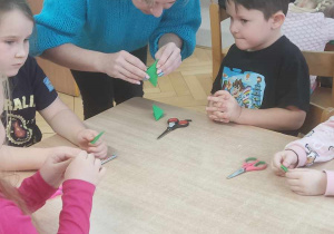 Dzieci z panią Justyna wycinają koniczynki.