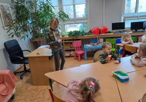 Dzieci słuchają Pani bibliotekarki, która zapoznaje grupę średniaków z bajką o żółwiu Franklinie i jego walentynkowych przygodach.