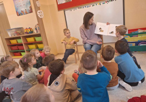 Mama czytająca przedszkolakom bajkę.