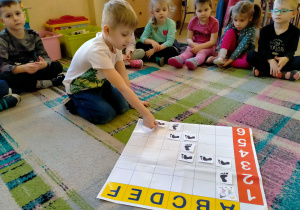 Chłopiec kładzie "Ślad" na macie do kodowania.