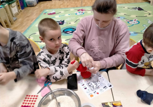 Chłopiec ozdabia z mamą "skarpetkowego" zajączka.