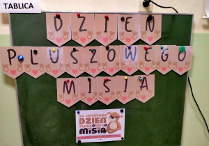 Napis "Dzień pluszowego misia" i plakat o tym święcie.