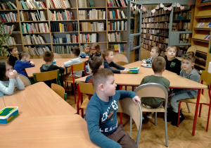 Dzieci słuchają bajki czytanej przez p. bibliotekarkę.