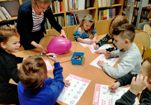 Dzieci wykonują matematyczne karty pracy o tematyce walentynkowej.