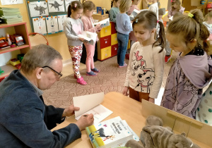 Pisarz wypisuje w swojej książce, dedykację dla Lidki.