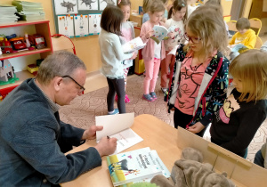 Pisarz wypisuje w swojej książce, dedykację dla Natalki.