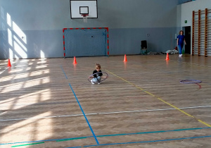 Dziewczynka przechodzi przez hula-hop.