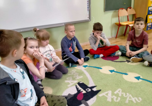 Dzieci oglądają zdjęcia, przedstawiające powstawanie glinianych przedmiotów.