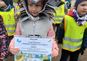 Dziewczynka w stroju jeża z nagrodą w ręku za zajęcie II miejsca w Wielkiej Paradzie Jeża