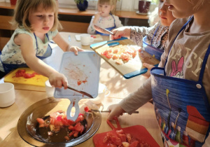 dzieci wrzucają owoce do miski