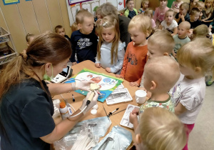 Pani stomatolog prezentuje dzieciom sprzęt dentystyczny.