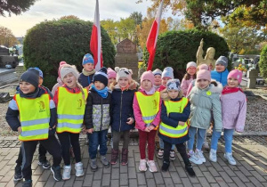 Zdjęcie grupowe przed grobem żołnierzy z I wojny światowej