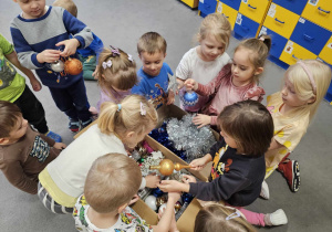 dzieci oglądają ozdoby choinkowe