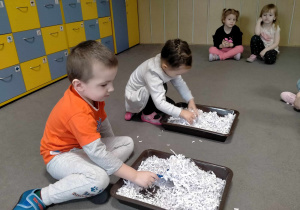 Dziewczynka z chłopcem szukali "szkieletów" dinozaurów w trocinach.