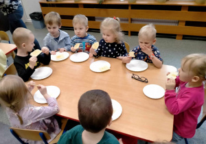 Dzieci jedzą wafle z miodem.