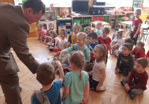 Dzieci oglądają gałązkę z wierzbowymi kotkami