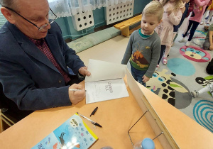 autor podpisuje książki dzieciom